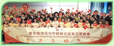 小学生们于港澳码头热烈欢迎刚为香港取得第五届东亚运动会主办权的申办委员会。