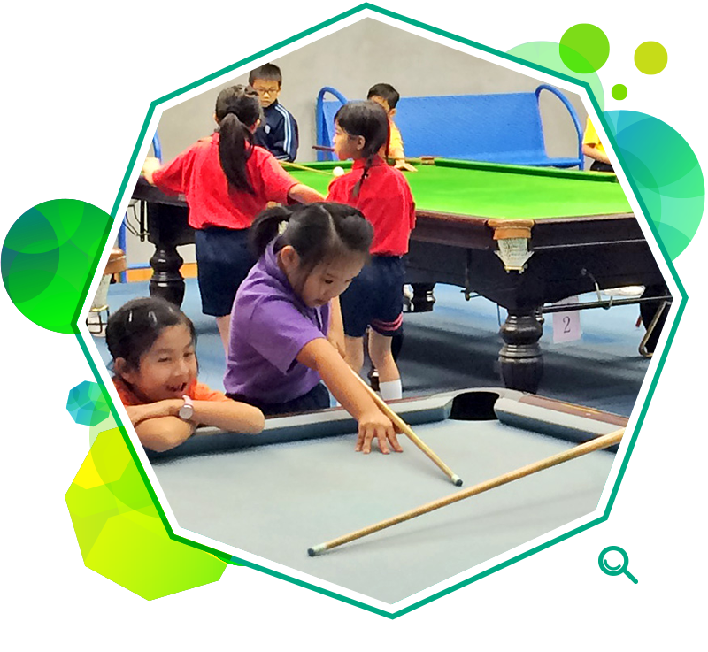 A group of children learning the basic skills of billiards. 