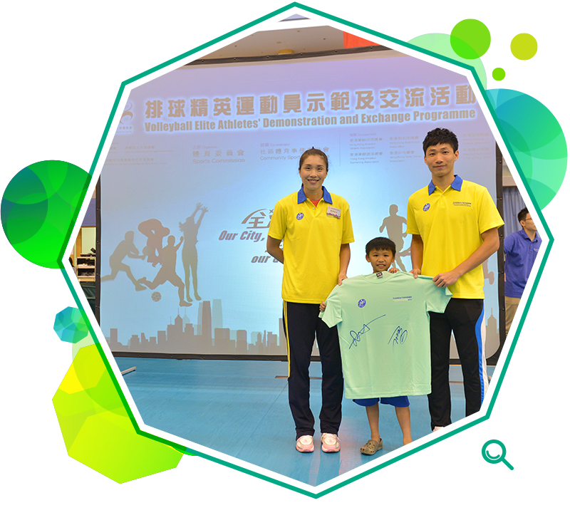 A child is presented with an autographed T-shirt by elite volleyball players at a demonstration and exchange activity.