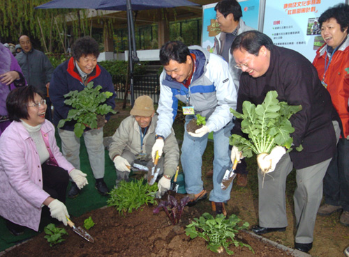 民政事務局局長何志平（右前方）和康樂及文化事務署署長王倩儀（左方跪立）為「社區園圃計劃」揭幕。