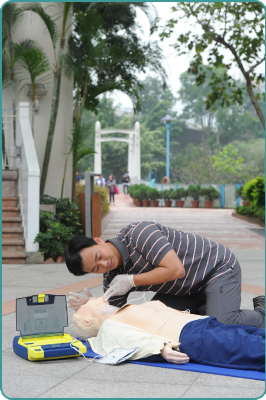 A staff member demonstrating the use of Automated External Defibrillators.