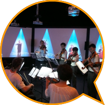 Students playing music with 'virtual musicians' from the Australian Chamber Orchestra in <i>ACO Virtual</i>..