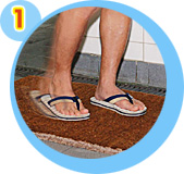 Scrub slippers against a coarse mat placed at a designated area to remove any dirt on the bases of the slippers;