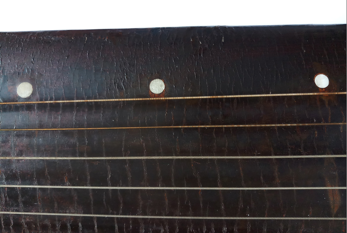 Cracks developed on the lacquer surface of an antique guqin over the years.